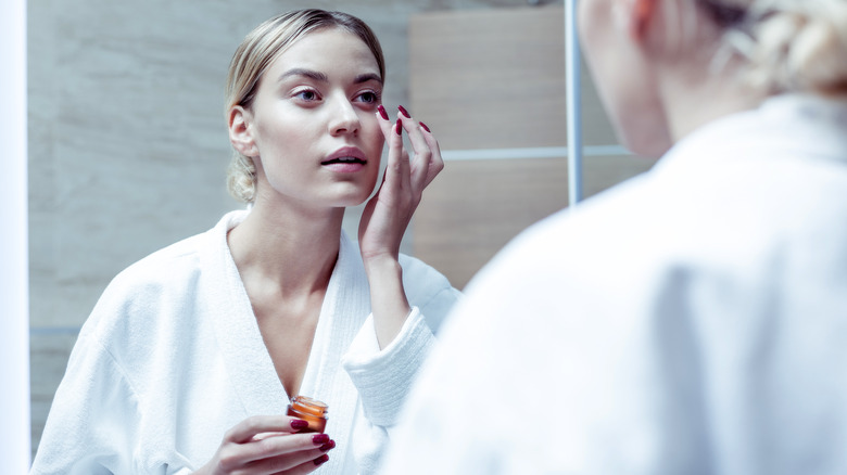 Woman applying eye cream 