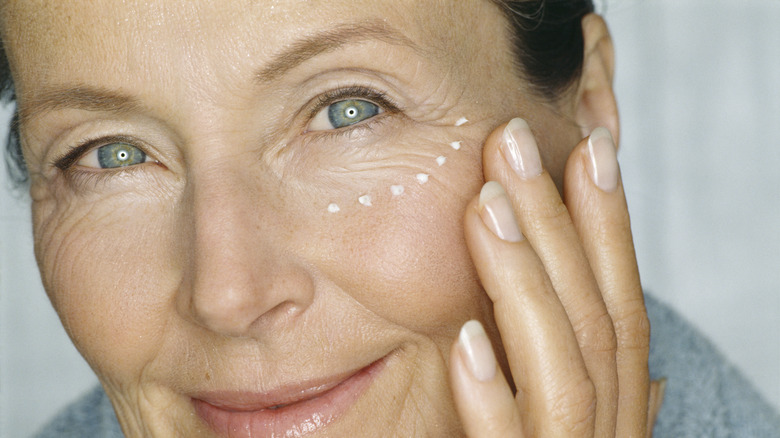 Woman with eye cream under eye