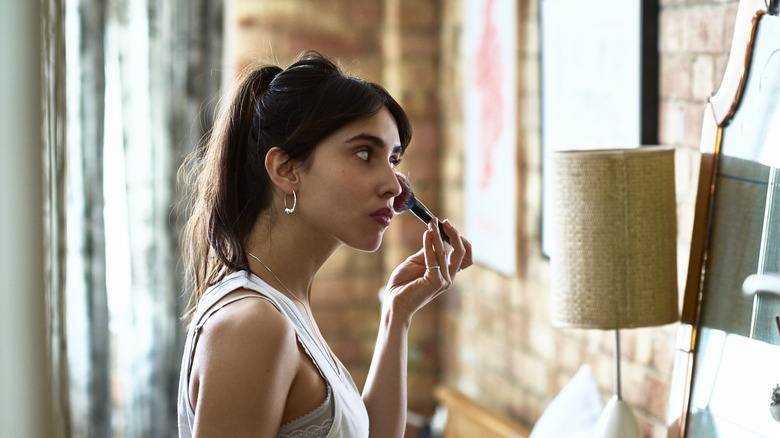 A woman applying blush