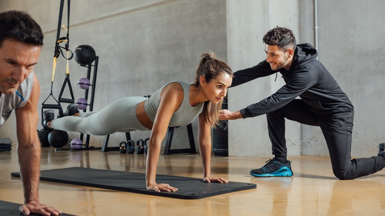  instructor helping client at gym 