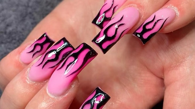 black flame nail art on pink nails