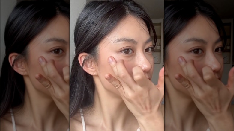 woman applying cream blush with finger