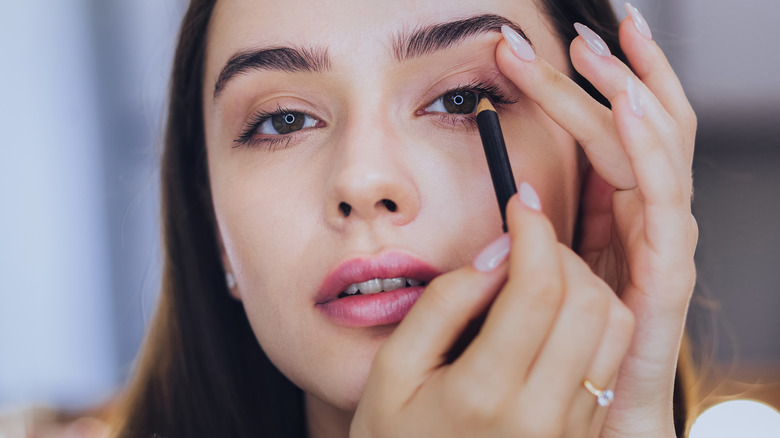 Woman doing eye makeup