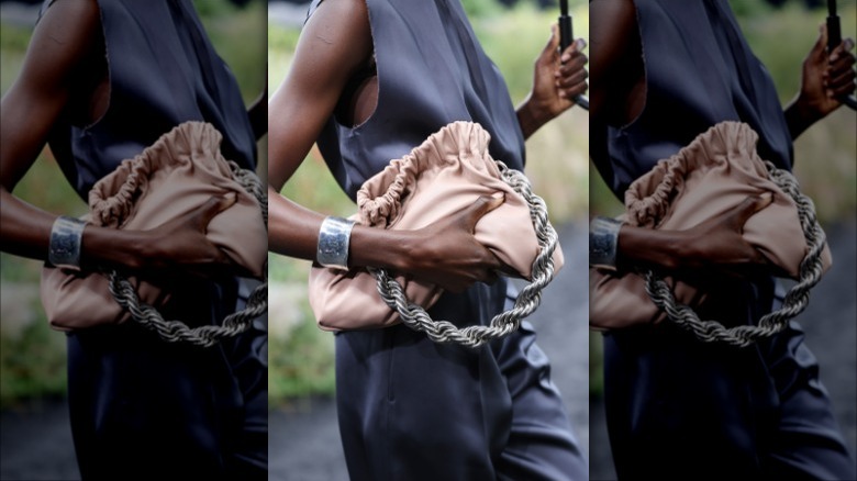 Woman holding beige bag, braided handle