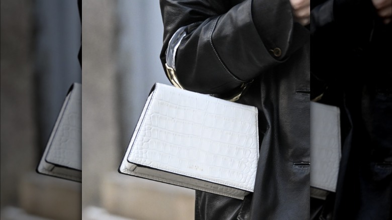 Woman holding white croc bag