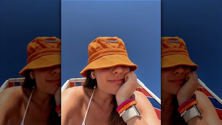 woman wearing orange jacquemus bucket hat