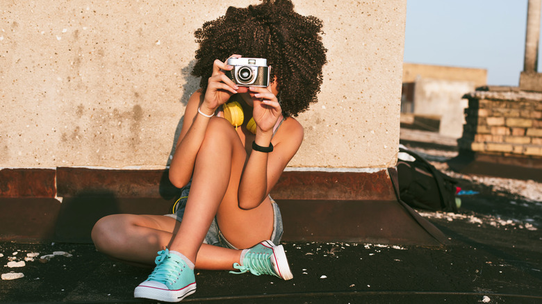 Woman with camera blue sneakers