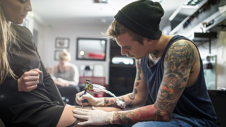 Woman getting her leg tattooed 