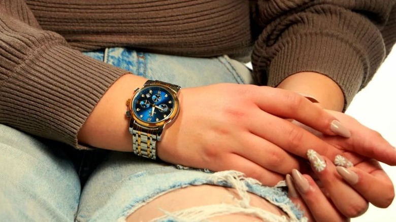 Woman models two-toned watch with blue face