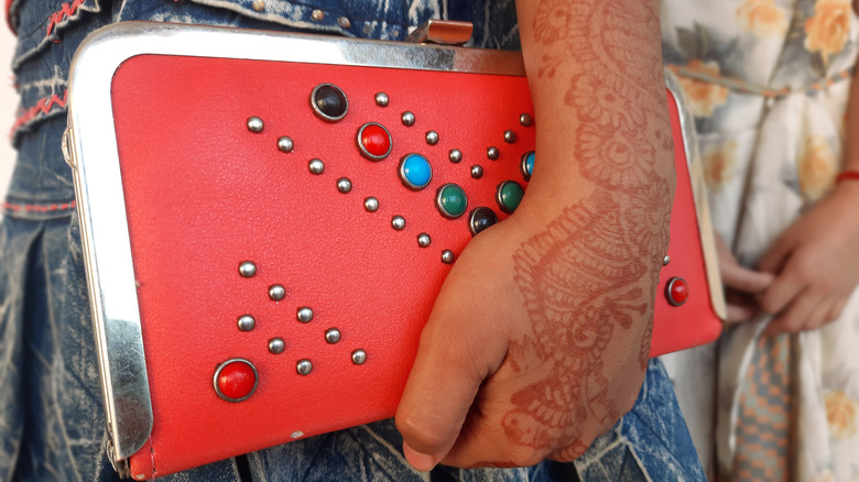 Woman holding stylish red purse 