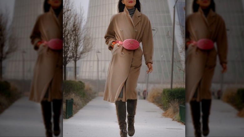 woman wearing a camel coat and a pink bag