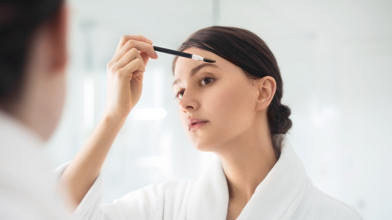 woman combing eyebrows