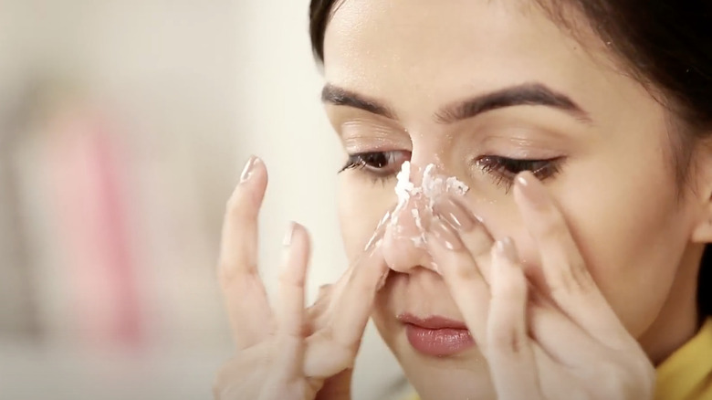 woman applying baking soda to nose 