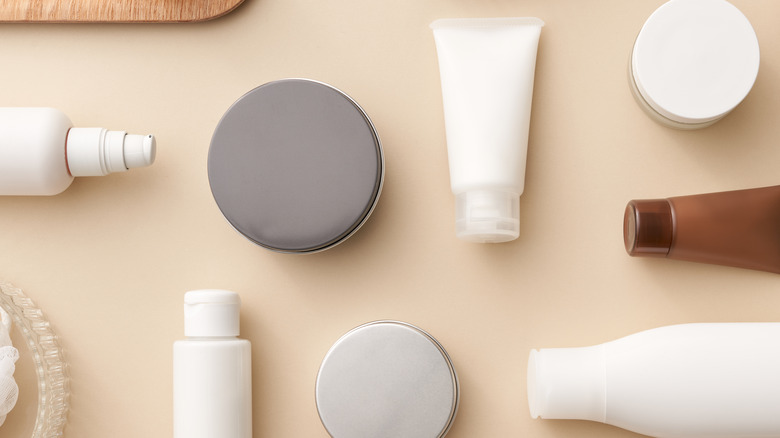 different types of cosmetic packaging on beige background