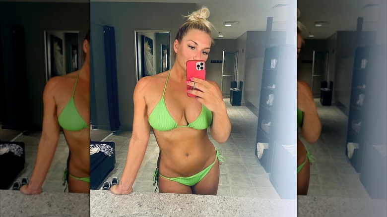 Brooke Hogan in a green swimsuit taking a selfie