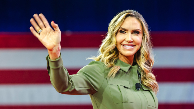 Lara Trump waving in an olive green jumpsuit.