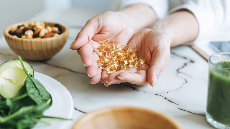 Woman with handful of vitamin capsules