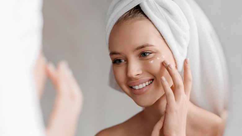 Woman dotting on concealer under eye