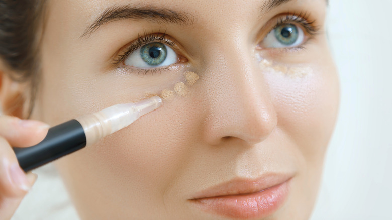 Woman applying concealer