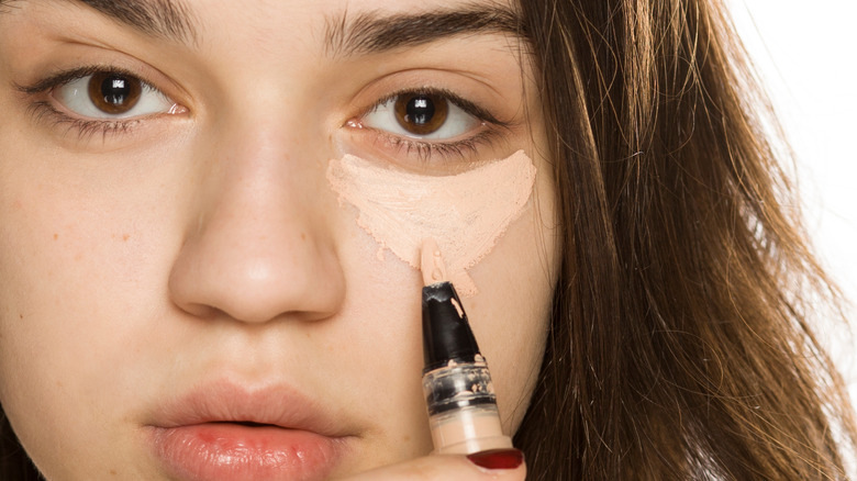 Girl applying concealer