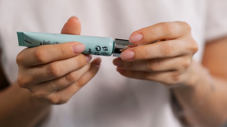 Woman opening green color corrector