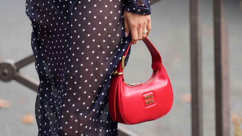 Woman carrying red Miu Miu handbag