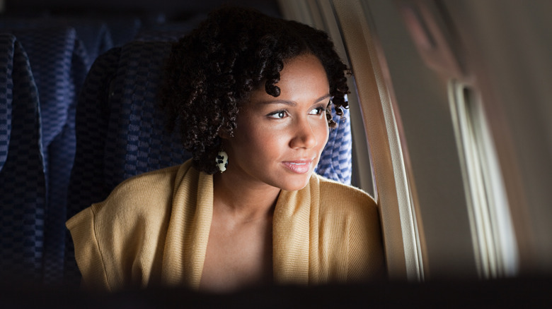 woman looking out plane window