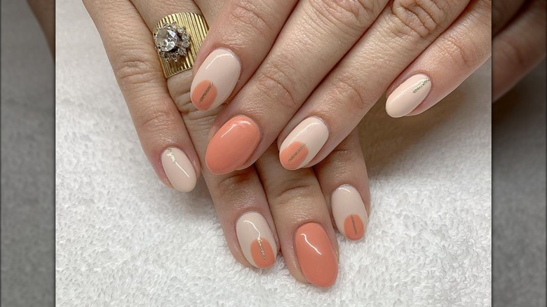 Cream-based nails with orange and golden details