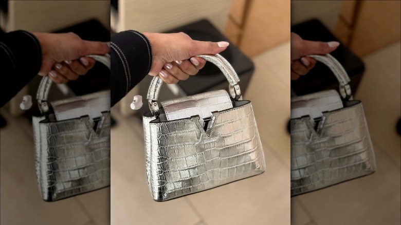 woman holding crocodile print handbag