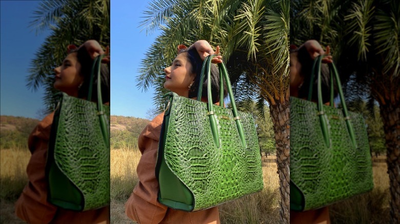 woman holding crocodile print handbag