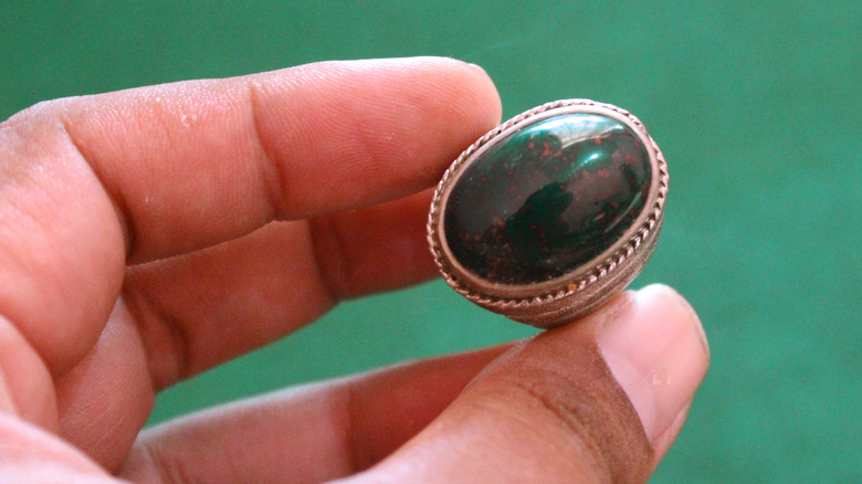 person examining bloodstone ring