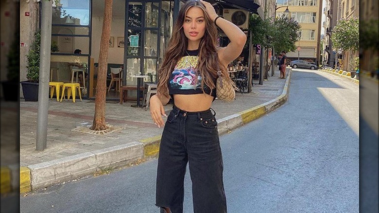 woman wearing crop top with ripped baggy jeans