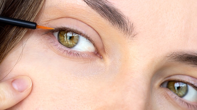 Woman applying lash serum