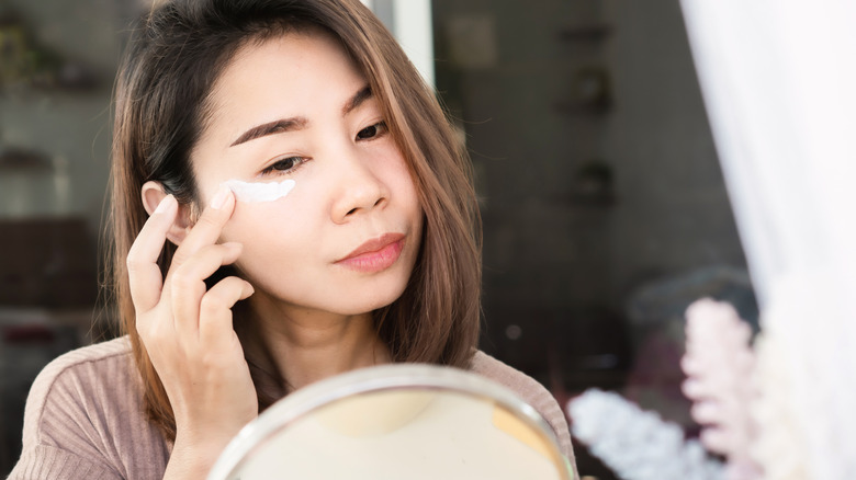 Woman applying eye cream