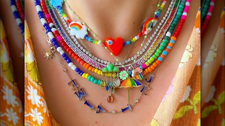 Person wearing beaded rainbow necklaces 