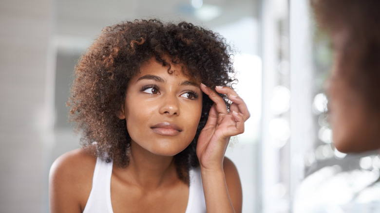 woman touching eyebrow