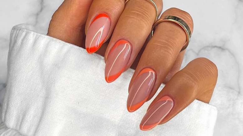 almond-shaped nails with orange double-corner lines