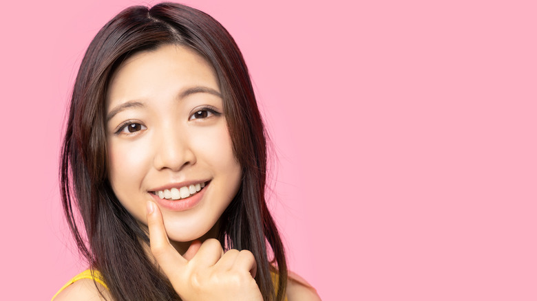 Woman smiling pink background