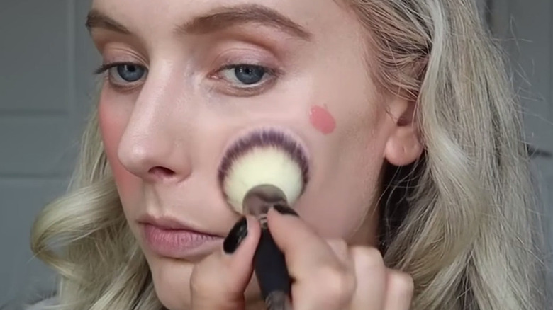 woman blending cream blush 