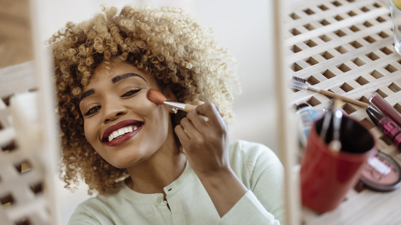 Woman blending foundation with brush