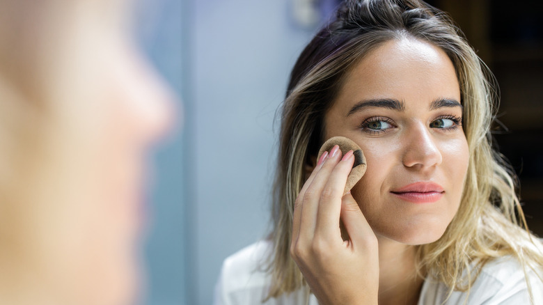 Woman blending out foundation