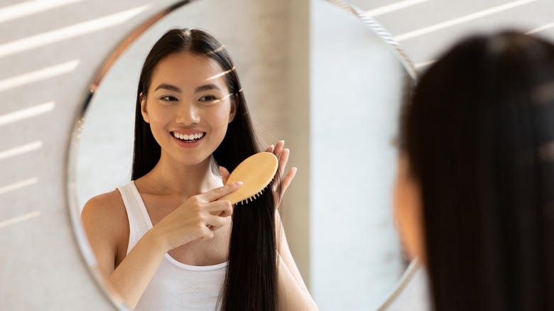 smiling woman brushing straight hair
