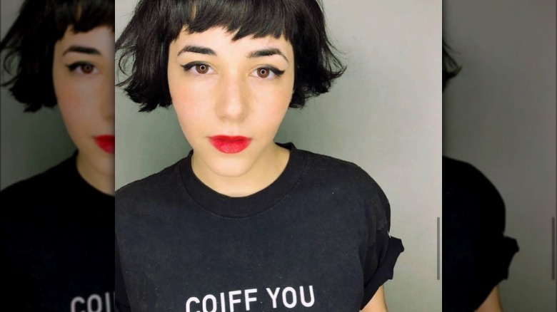 Woman models short bob haircut with choppy bangs