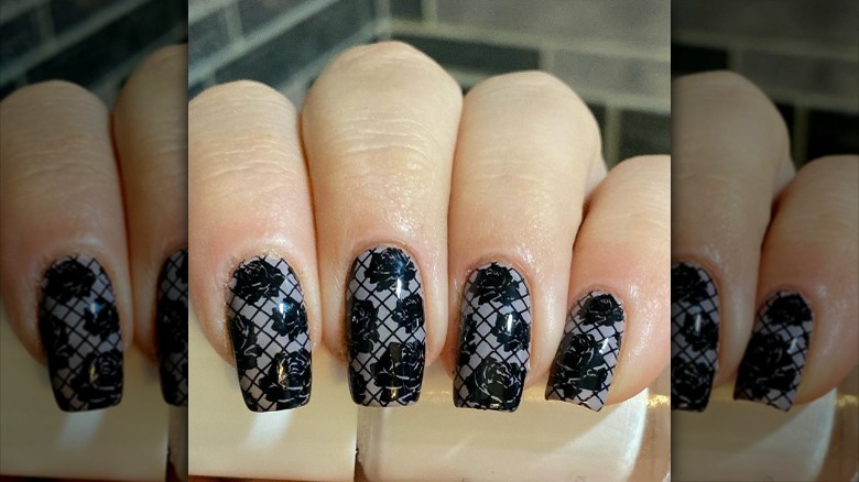 fingers with black lace nails
