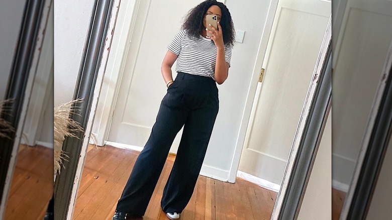 woman taking selfie in black pants