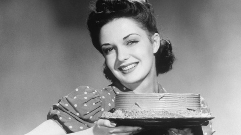 1940s era woman holding a cake 