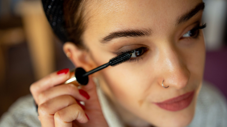 Woman applying mascara