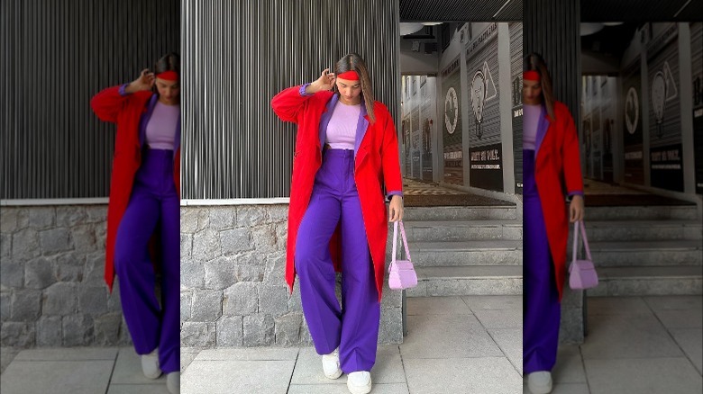 Girl wearing a red coat over a purple suit.