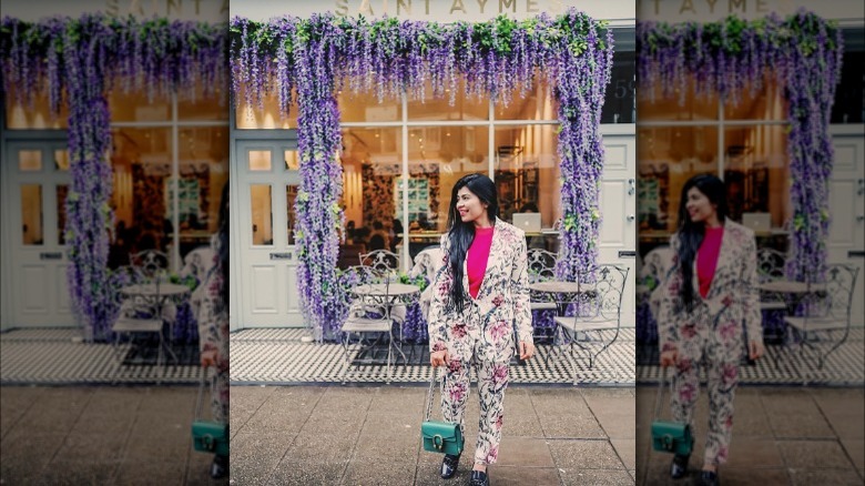 Woman wearing a floral pantsuit.
