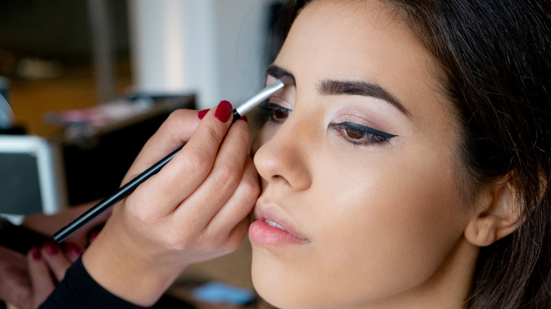 makeup artist applying eyebrow shadow